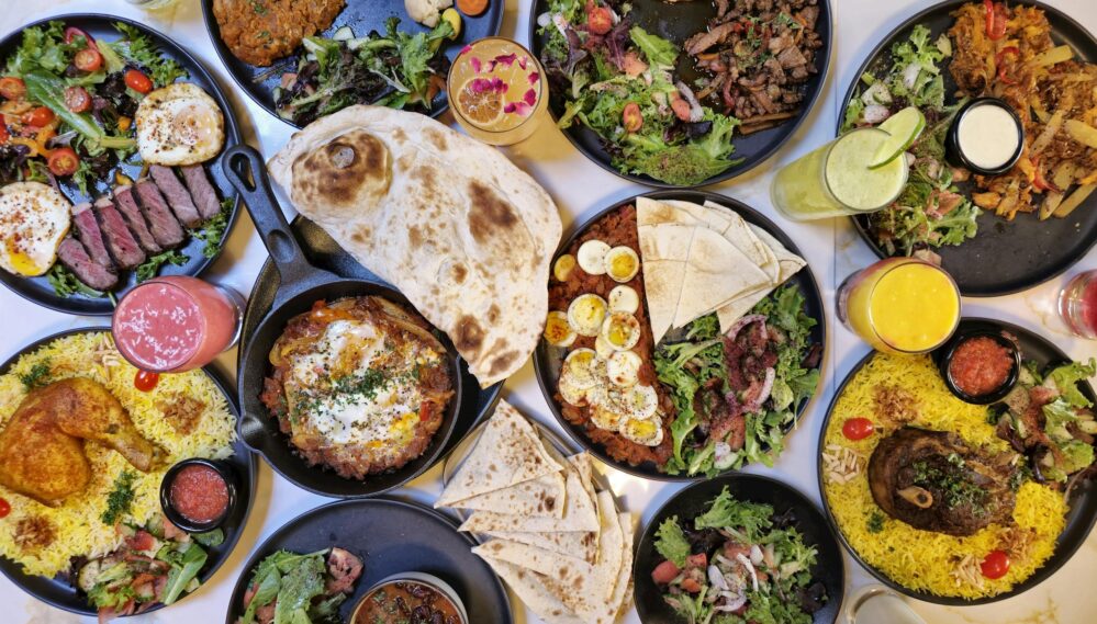 A vibrant spread of Middle Eastern dishes with fresh salads and drinks, captured in Vancouver.