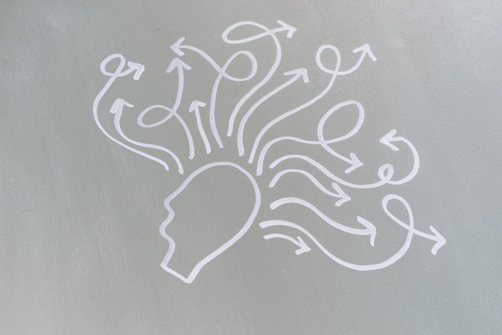 Chalk drawing of a head with swirling arrows represents mental activity and thought process.